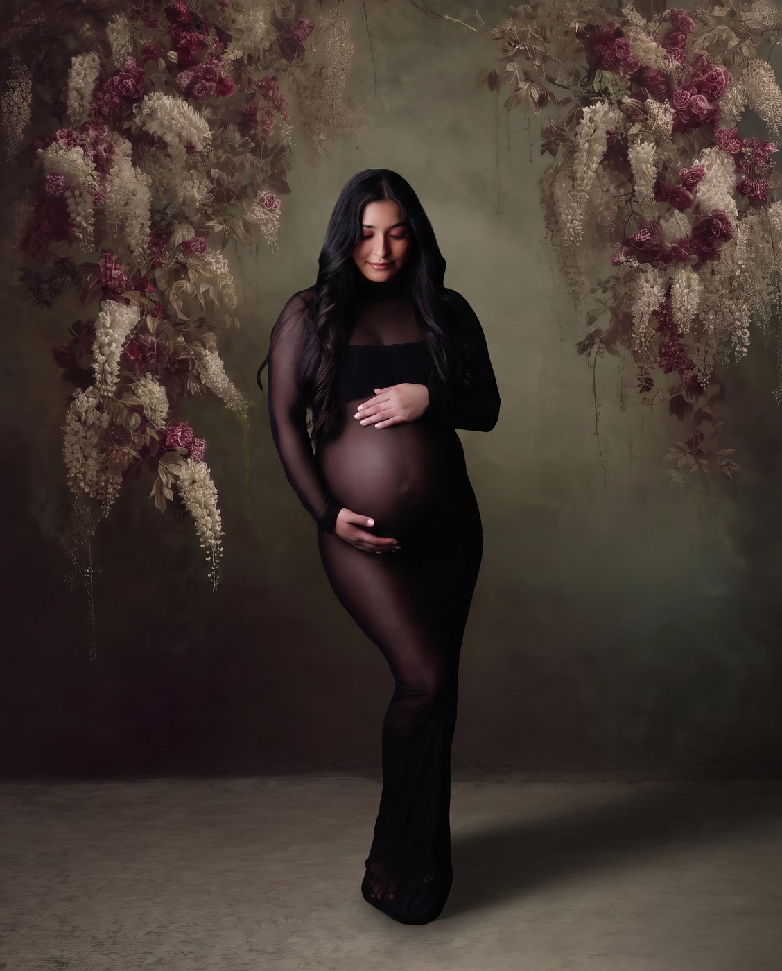 Maternity portrait against a dark floral backdrop