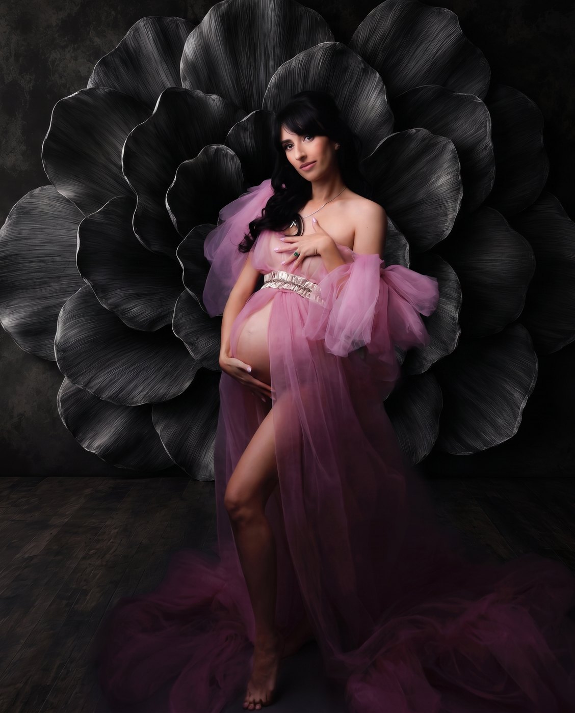 Maternity portrait against a large dark paper-flower wall